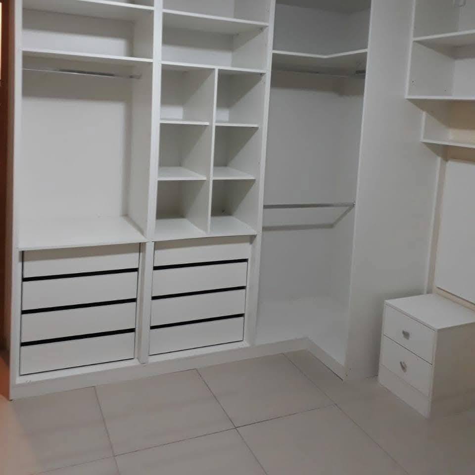 Closet aberto com gaveteiros e cabideiros