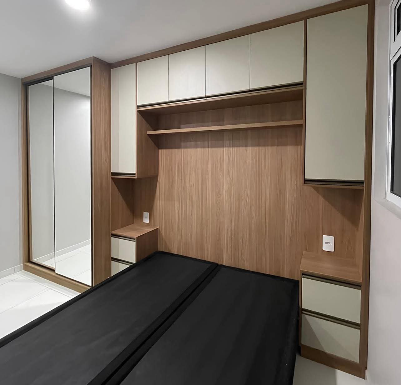 Quarto planejado com espelho e cabeceira em madeira